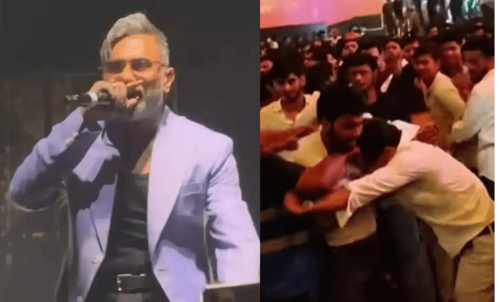 Rapper Yo Yo Honey Singh performing live on a high-tech stage at Indira Gandhi Indoor Stadium, Delhi, surrounded by blue lights and a massive crowd.