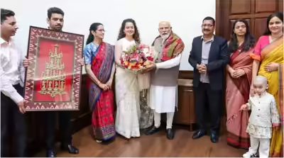 Kangana Ranaut in a white handloom silk saree gifting a Dashavatara brass frame to PM Narendra Modi at his New Delhi residence.