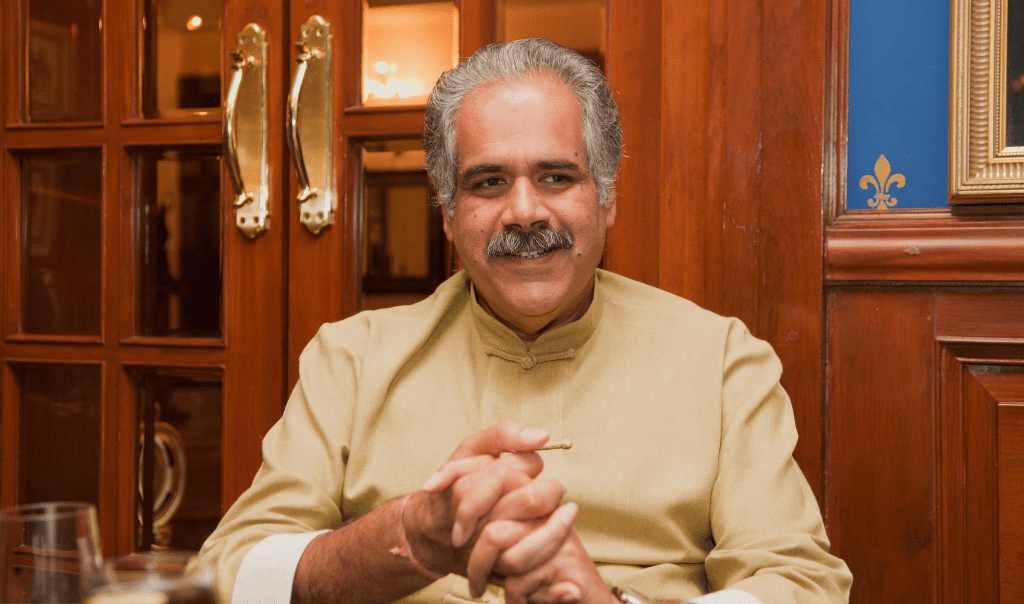 A professional headshot of Rahul Bhatia, co-founder of IndiGo, looking forward with a neutral expression against a blurred office background.