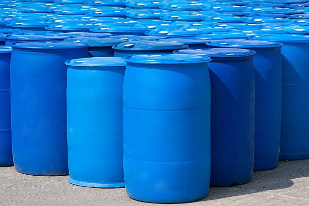 A blue plastic industrial drum sitting in a dimly lit corner, representing the "blue drum" murder threats reported in Uttar Pradesh.